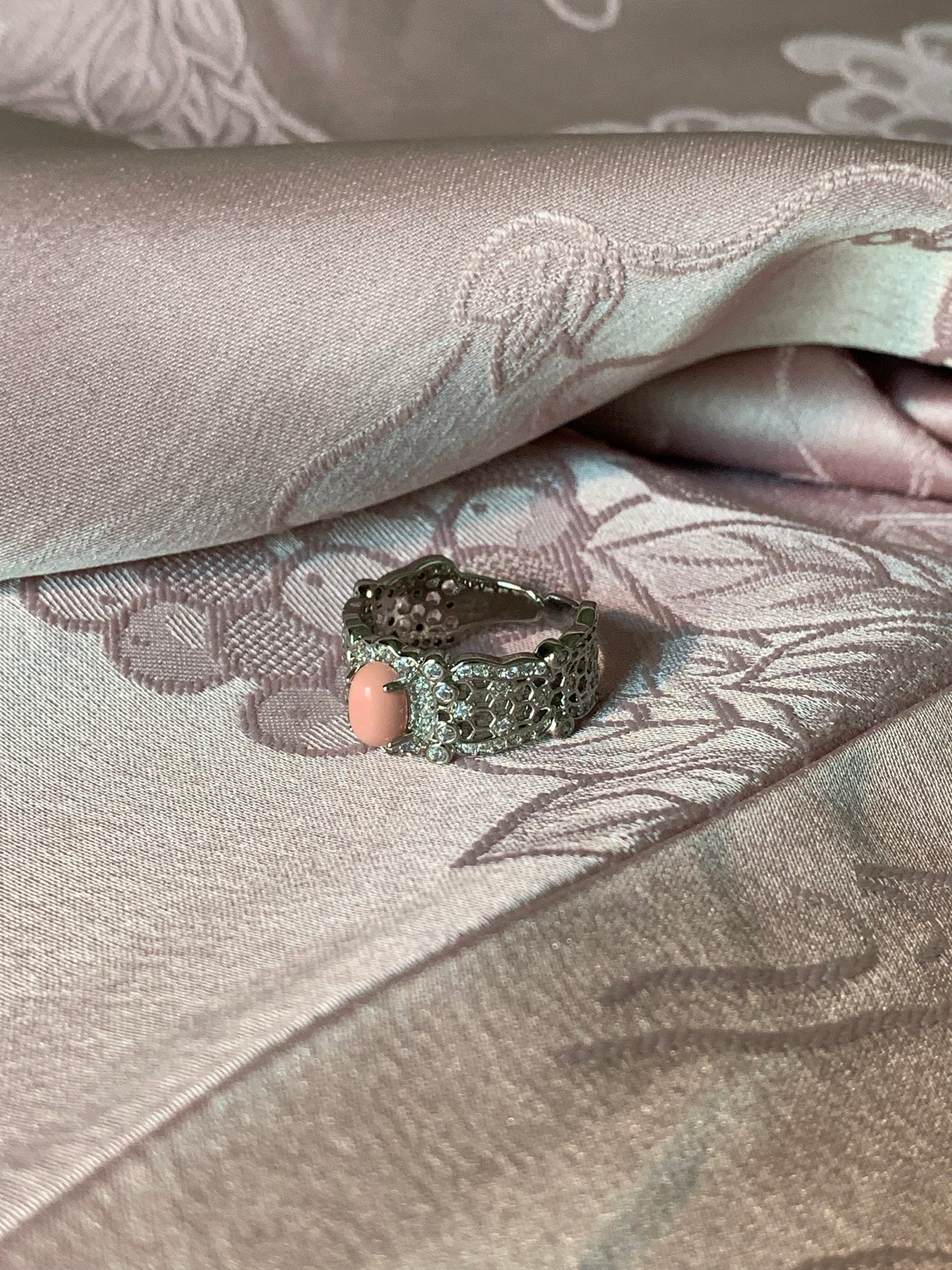 Harmony Power Rose Shell Ring styled in a cozy lifestyle setting with candles and delicate fabrics, perfect for a serene ambiance.