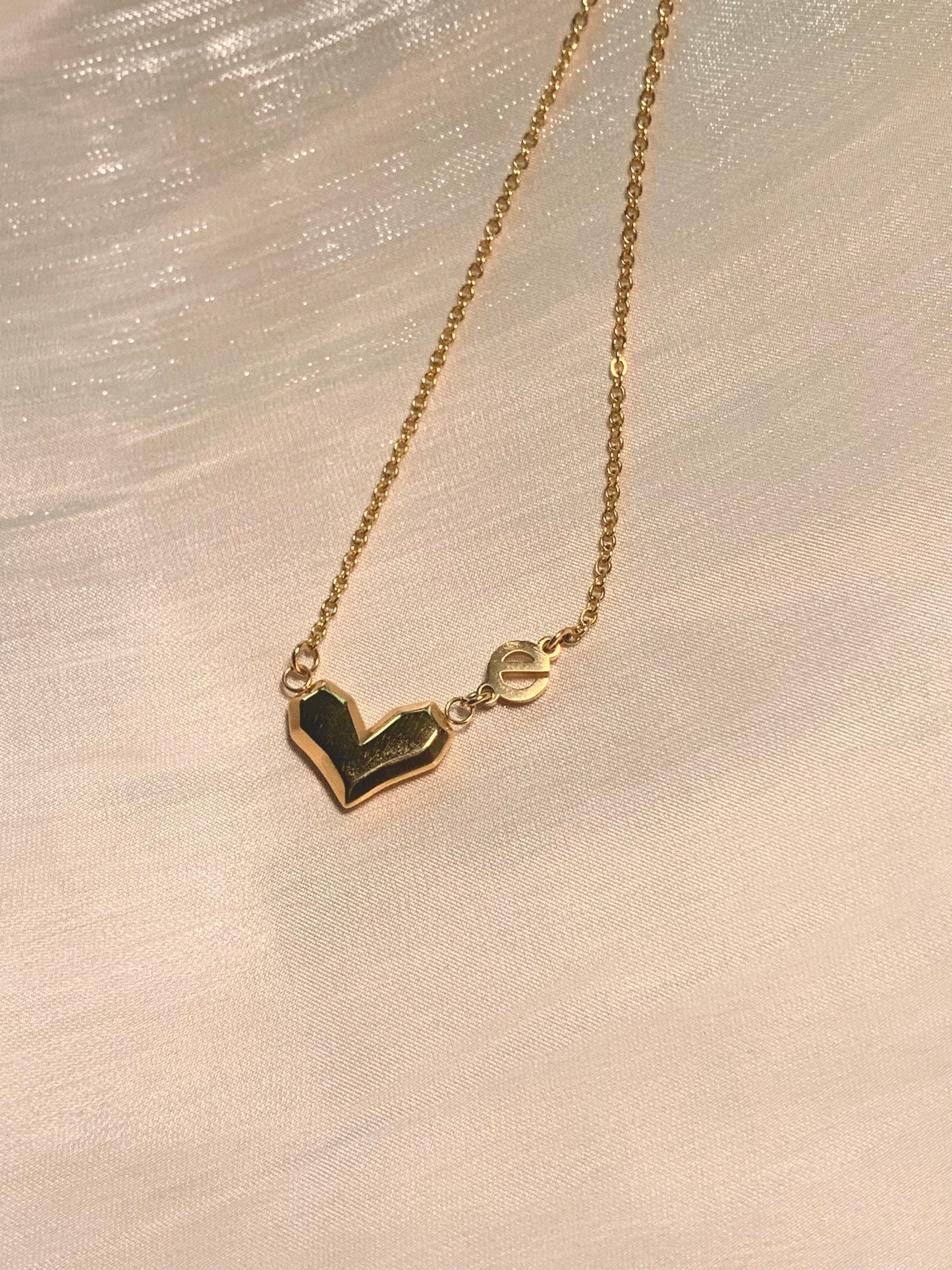 Gold heart necklace on a soft background, embodying the essence of empowerment and self-love.