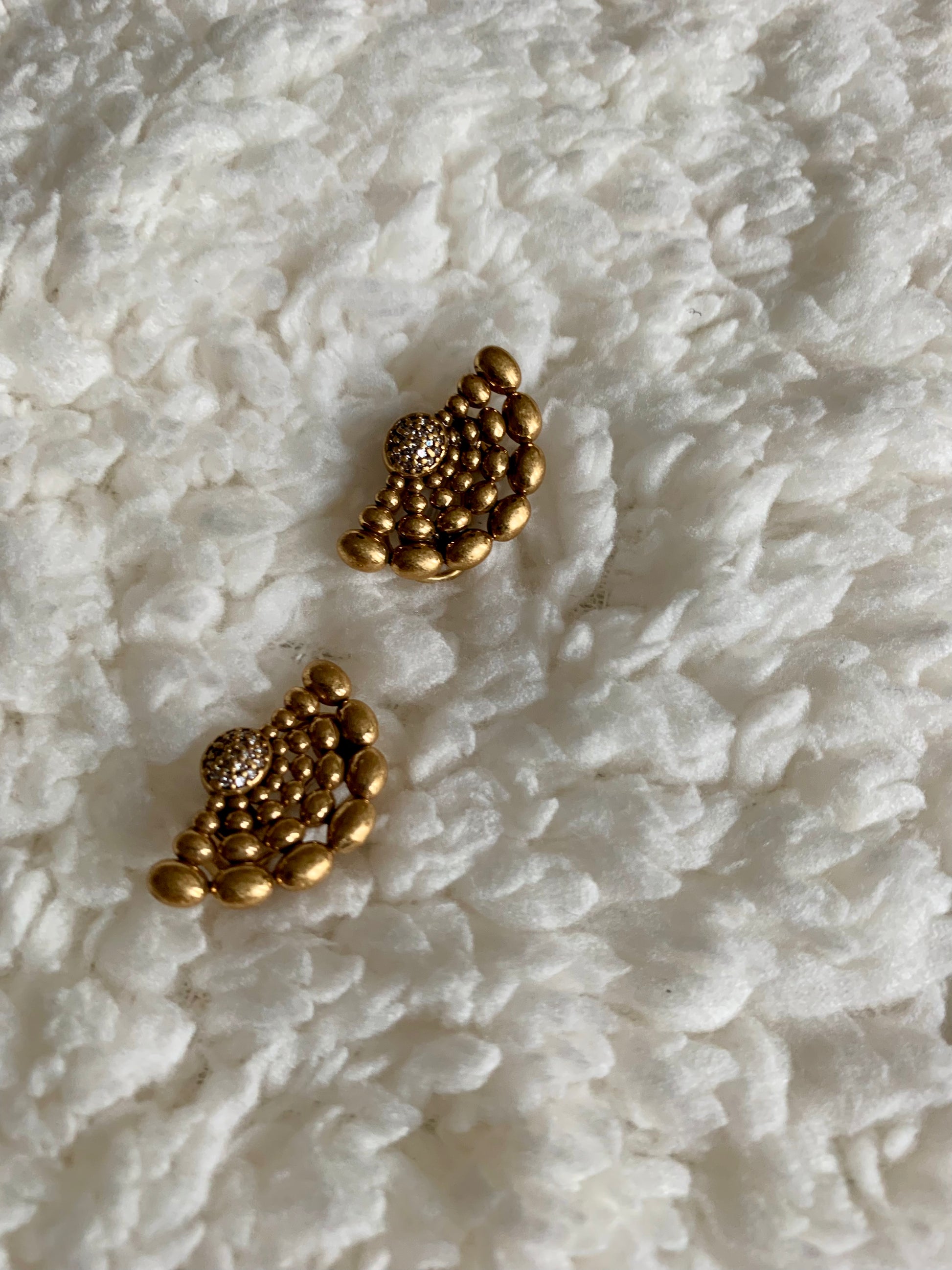 Close-up of the Spirit Power golden earrings showcasing their intricate retro patterns.
