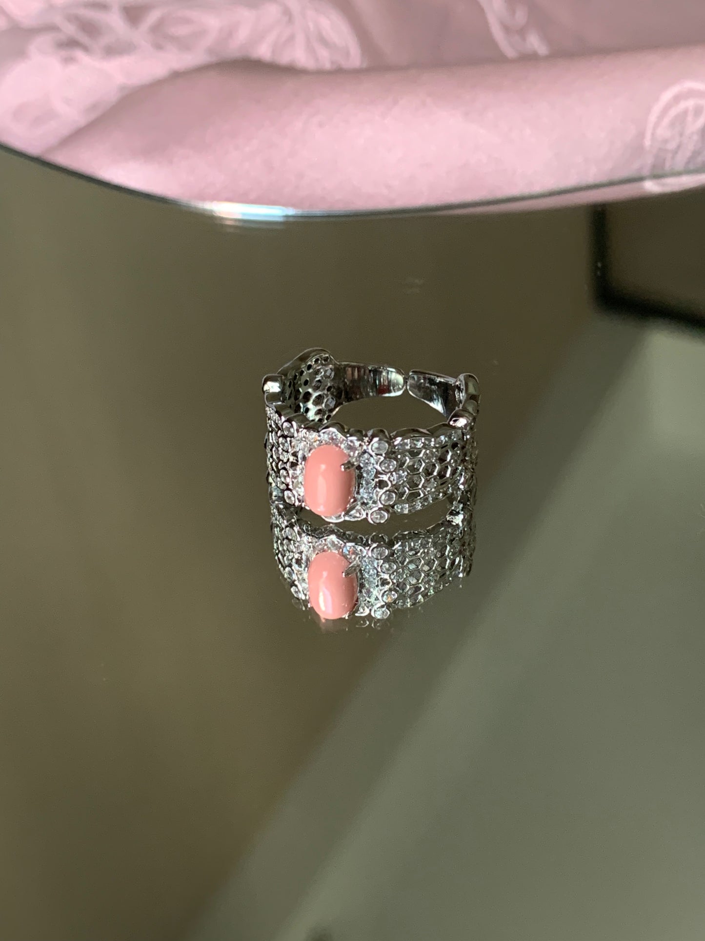 Harmony Power Rose Shell Ring elegantly displayed on a marble surface surrounded by soft flowers, creating a romantic atmosphere.