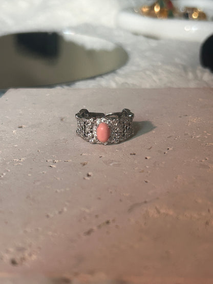 Harmony Power Rose Shell Ring captured among natural elements like seashells and soft greenery, reflecting its oceanic inspiration.