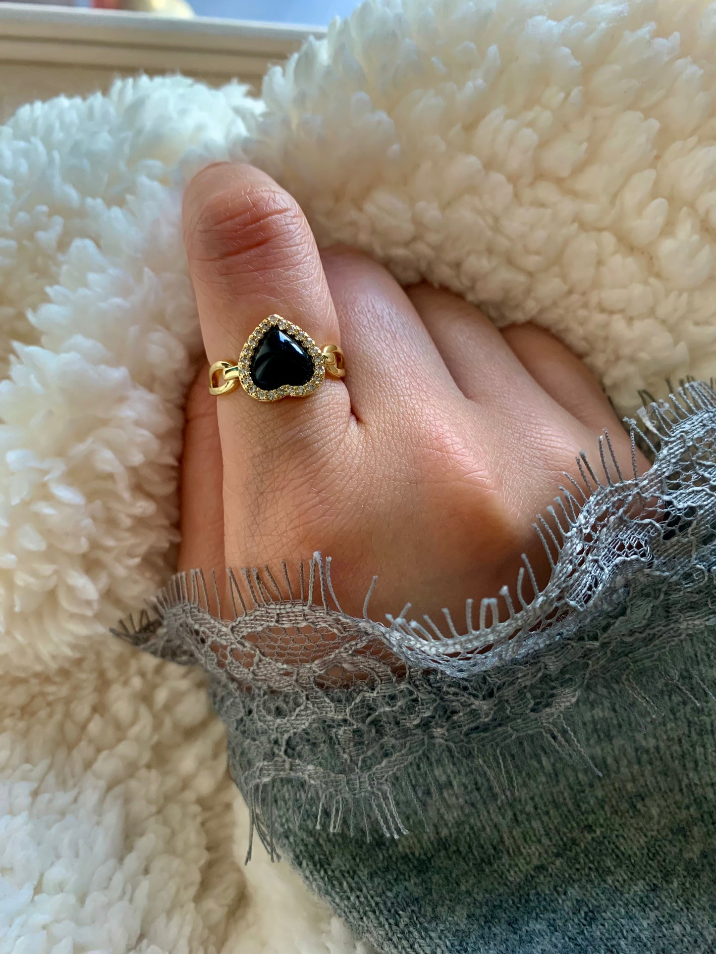 Elegant shot of a woman wearing the Love Power Obsidian Heart Gold Ring, featuring a heart-shaped obsidian stone and sparkling zirconia, perfect for adding a touch of sophistication to any outfit.