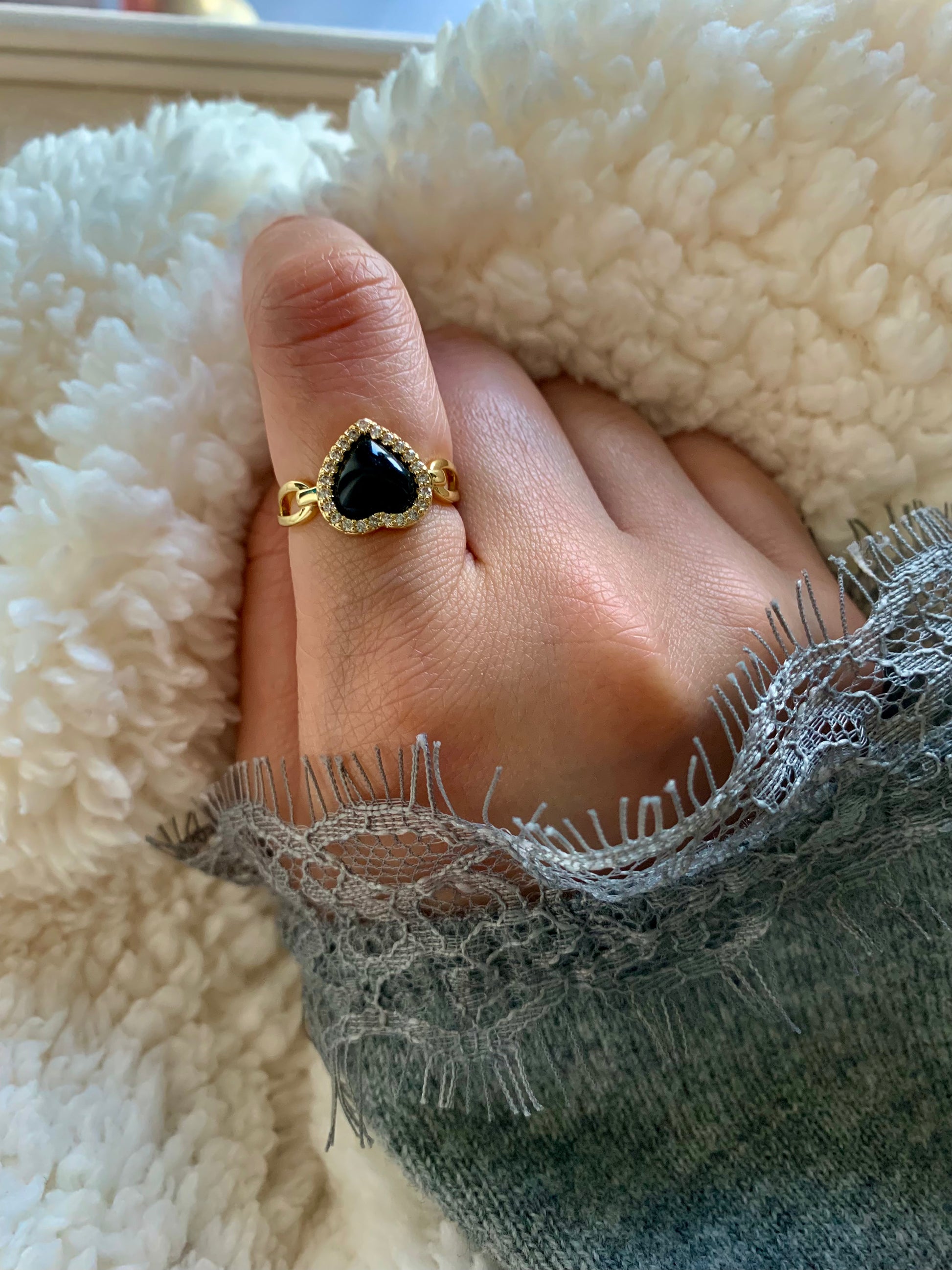 Elegant shot of a woman wearing the Love Power Obsidian Heart Gold Ring, featuring a heart-shaped obsidian stone and sparkling zirconia, perfect for adding a touch of sophistication to any outfit.