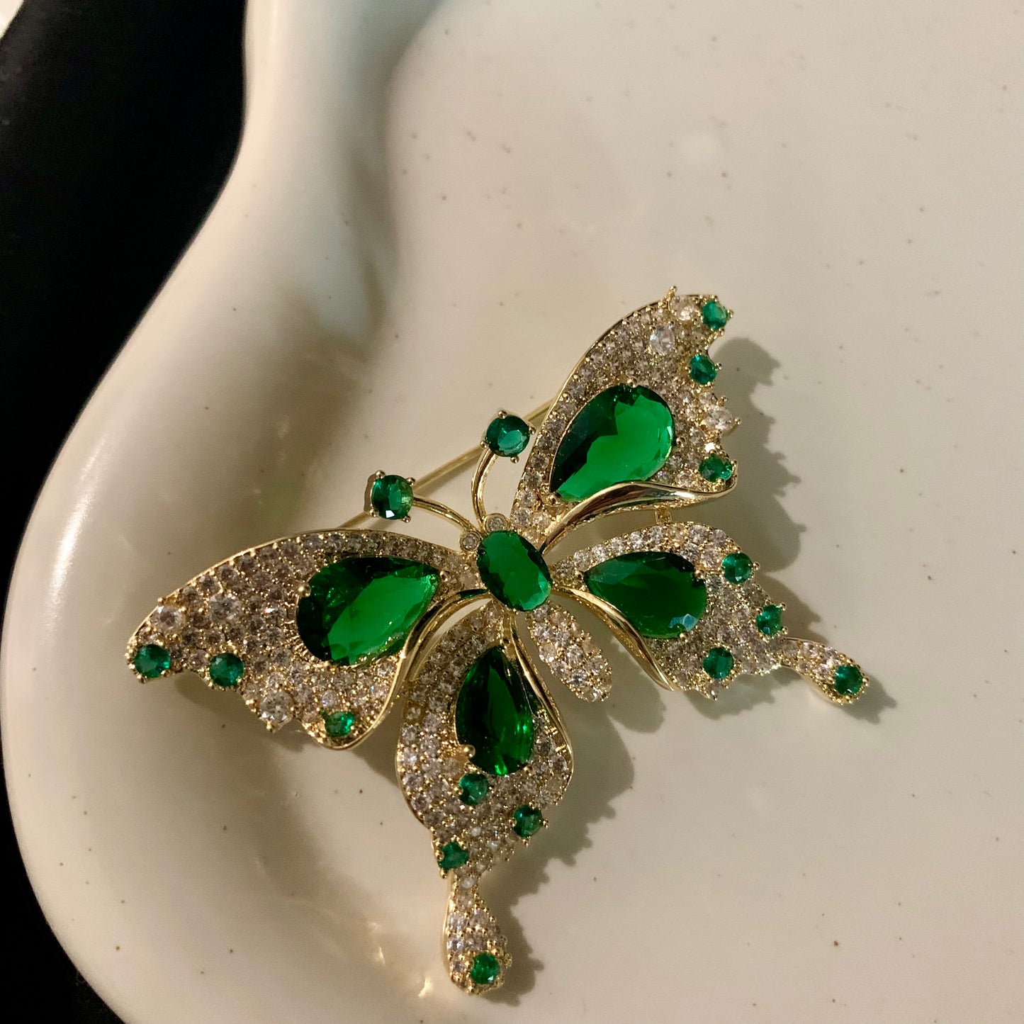 Close-up of a green gem butterfly brooch, showcasing its beautiful craftsmanship and unique frost finish.