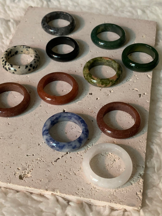 A stunning collection of 12 unique rings including White Crystal, Rose Quartz, Strawberry Quartz, and more, beautifully arranged for display.