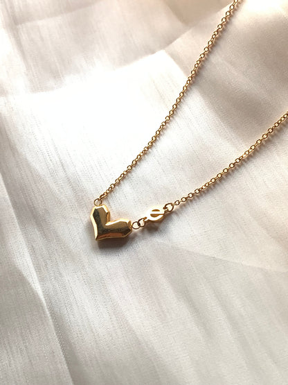 Close-up of the Love Power Heart Gold Necklace, symbolizing love and female empowerment.