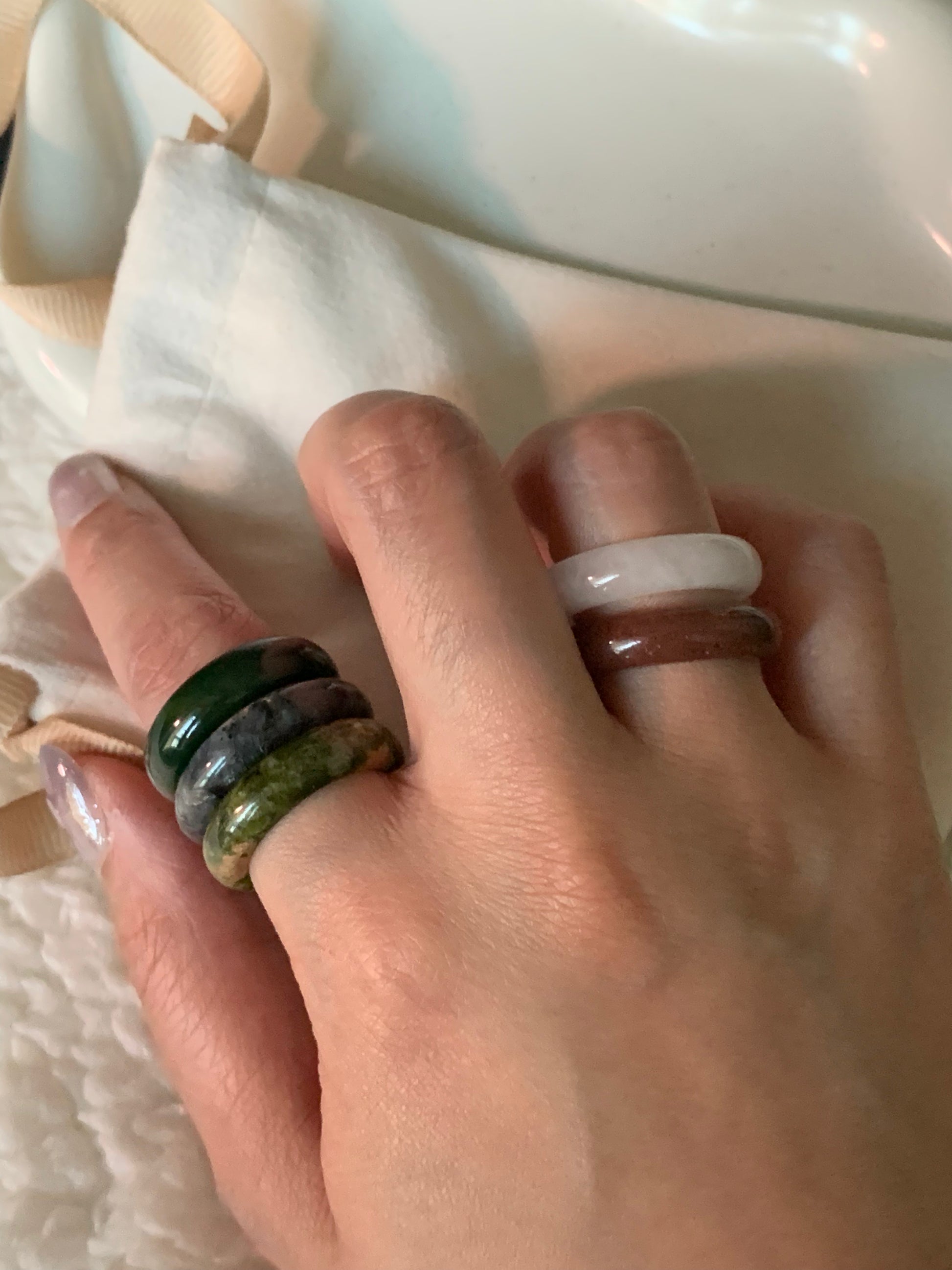 An elegant arrangement of multiple rings layered together, highlighting their unique designs and color combinations.